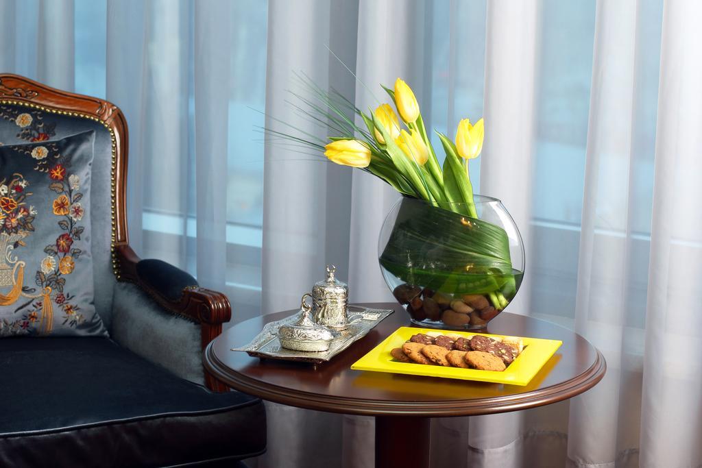 Orion Hotel บิชเคก ภายนอก รูปภาพ A table with a vase of flowers